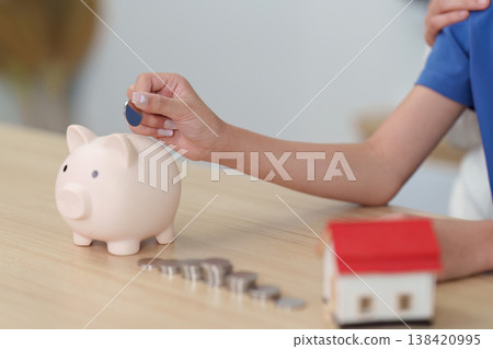 Child saving coins in piggy bank for financial education 138420995