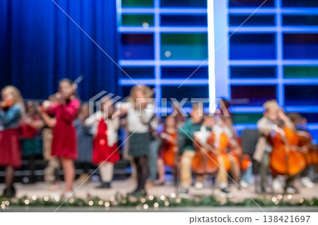 Defocused middle school orchestra band on stage for a concert. Defocused middle school orchestra band on stage for a concert. 138421697