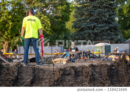 Event official stands as spectators prepare for action at a demolition derby at a local fairground in the afternoon Event official stands as spectators prepare for action at a demolition derby at a local fairground in the afternoon 138421699