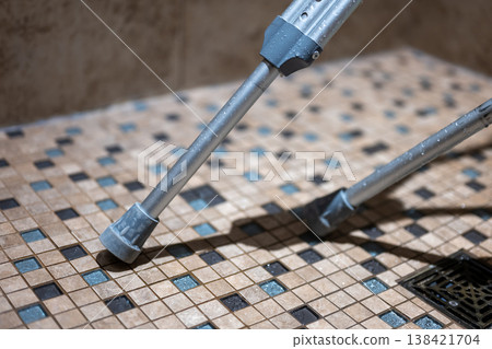 Walking aid rests on tiled floor in shower area during indoor activity at home Walking aid rests on tiled floor in shower area during indoor activity at home 138421704