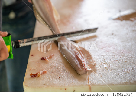 Filleting fish in a seafood market during the early morning hours in a coastal town 138421734