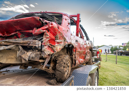 Dented and damaged rear end of a modified car used for a demolition derby loaded on a trailer Dented and damaged rear end of a modified car used for a demolition derby loaded on a trailer 138421850