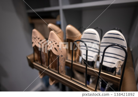 Collection of shoes displayed on a rack in a modern room for easy access and organization at any time of the day Collection of shoes displayed on a rack in a modern room for easy access and organization at any time of the day 138421892