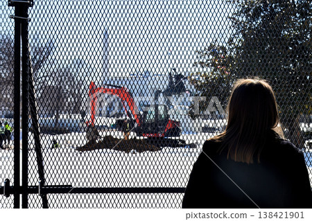 Construction work is in progress at the White House in the winter with people observing and taking pictures from behind a fence Construction work is in progress at the White House in the winter with people observing and taking pictures from behind a fence 138421901