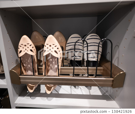 Stylish shoes arranged on a storage shelf in a closet for easy access and organization during the day Stylish shoes arranged on a storage shelf in a closet for easy access and organization during the day 138421926