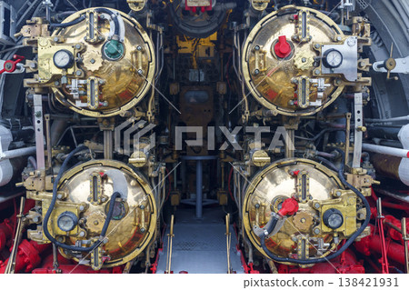 Submarine torpedo room with four brass torpedo tubes and mechanical control systems. Submarine torpedo room with four brass torpedo tubes and mechanical control systems. 138421931