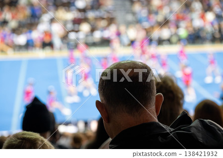 Crowd watches cheerleading event in a sports arena on a weekend afternoon with many teams performing Crowd watches cheerleading event in a sports arena on a weekend afternoon with many teams performing 138421932