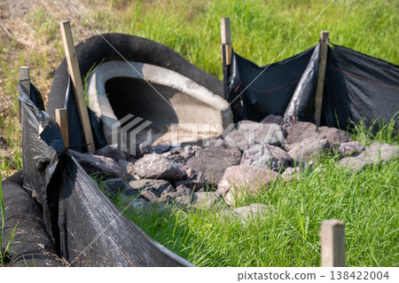 Construction site featuring a concrete structure surrounded by rocks and gravel during daylight hours 138422004