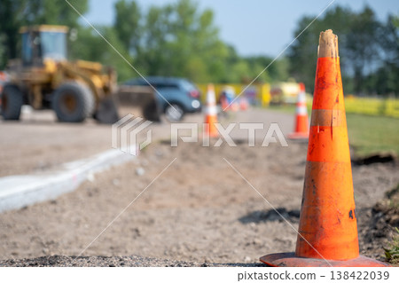 Construction site with heavy machinery and traffic cones on a warm, sunny day 138422039