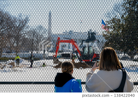 Construction work is in progress at the White House in the winter with people observing and taking pictures from behind a fence Construction work is in progress at the White House in the winter with people observing and taking pictures from behind a fence 138422040
