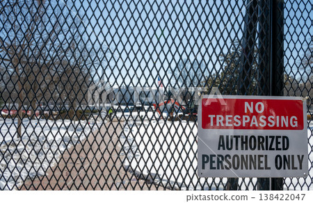 No trespassing sign displayed on a fence with snow coverage in the background at the United States White House in Washington DC 138422047