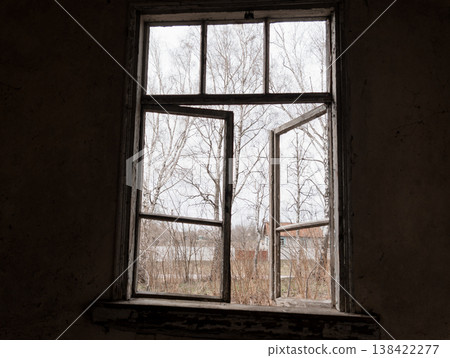 Weathered Open Window Frame Revealing Bare Winter Trees and Distant Rural Houses Through Peeling Paint in Abandoned Building Interior Scene 138422277