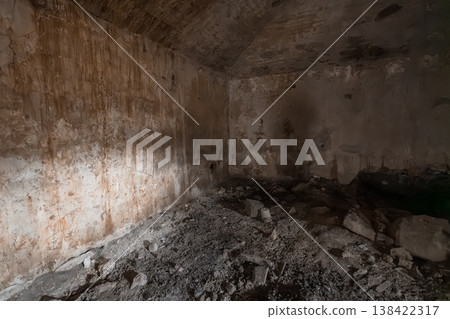 Abandoned Underground Concrete Bunker Interior With Peeling Walls, Debris Floor, Rust Stains, Dim Lighting And Decay Textures In Earthy Tones Abandoned Underground Concrete Bunker Interior With Peeling Walls, Debris Floor, Rust Stains, Dim Lighting And Decay Textures In Earthy Tones 138422317