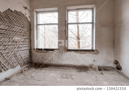 Dilapidated Room With Broken Windows Showing Bare Trees Outside Amidst Peeling White Walls And Exposed Wooden Lattice On Left Side In Abandoned Building Interior Scene 138422358
