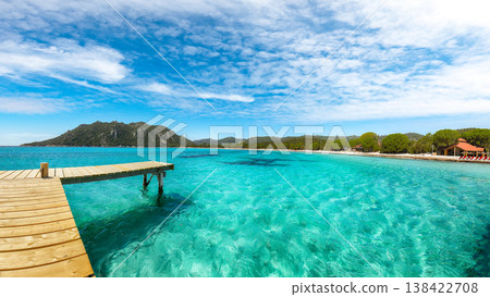 Breathtaking landscape with wooden pier on Santa Giulia beach. Breathtaking landscape with wooden pier on Santa Giulia beach. 138422708