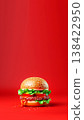 Delicious cheeseburger on a bright red background. a gourmet burger with sesame bun, juicy beef patty, lettuce, and tomato. Minimalist fast food advertising concept with copy space 138422950