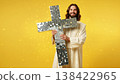 Creative depiction of Jesus on a sparkling cross made of disco mirror tiles with a warm yellow glow. Art Easter banner for design with copy space. Yellow Easter background 138422965