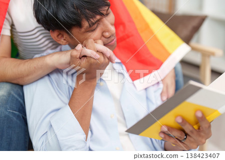 LGBTQ couple sharing a tender moment with a pride flag 138423407