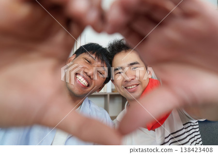 LGBTQ couple making a heart gesture together 138423408