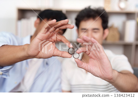 LGBTQ couple holding wedding rings together LGBTQ couple holding wedding rings together 138423412