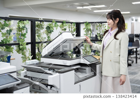 一名女員工在辦公室操作多功能印表機。 138423414