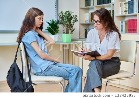 Teenage student girl meeting with school psychologist, counselor Teenage student girl meeting with school psychologist, counselor 138423953