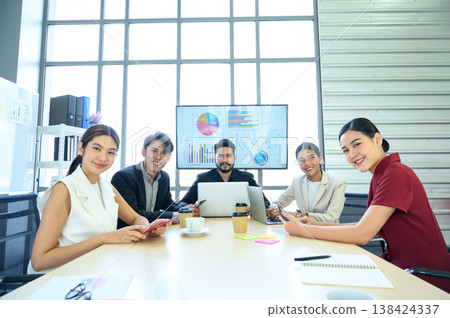 Business people group meeting in office. Professional businesswomen and businessmen working in team conference in the meeting room. Look at camera. Business people group meeting in office. Professional businesswomen and businessmen working in team conference in the meeting room. Look at camera. 138424337