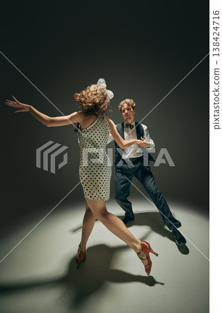 Vintage style couple dancing in polka dot dress fashion campaign scene. Vintage style couple dancing in polka dot dress fashion campaign scene. 138424716