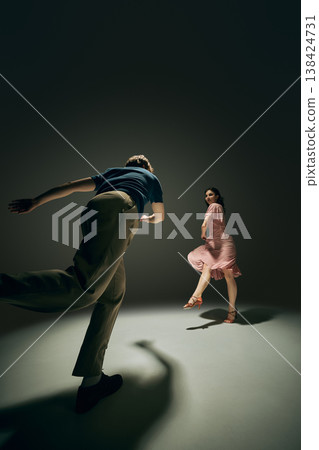 Dynamic lindy hop dance couple holding hands energetic movement studio composition. Dynamic lindy hop dance couple holding hands energetic movement studio composition. 138424731