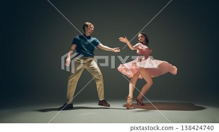 Young couple dancing lindy hop with flowing dress motion studio shot expressive movement. Young couple dancing lindy hop with flowing dress motion studio shot expressive movement. 138424740