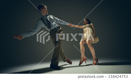 Retro style couple dancing lindy hop in studio with dramatic lighting expressive motion. Retro style couple dancing lindy hop in studio with dramatic lighting expressive motion. 138424753