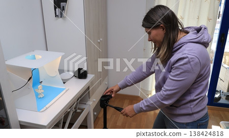 Woman meticulously arranges her equipment to capture a figure Woman meticulously arranges her equipment to capture a figure 138424818