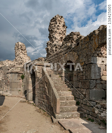 Historic Acropolis of Pergamon ruins with stone walls, arches, and staircase under cloudy sky, Bergama Turkey Historic Acropolis of Pergamon ruins with stone walls, arches, and staircase under cloudy sky, Bergama Turkey 138425005