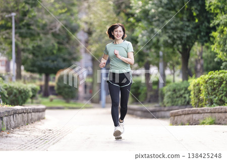 一位五十多歲的女性正在跑步 一位五十多歲的女性正在跑步 138425248