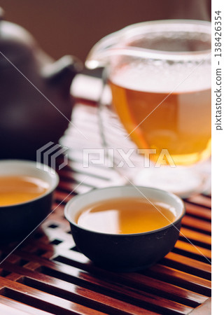 Teapot and cups with Chinese tea on the table Teapot and cups with Chinese tea on the table 138426354
