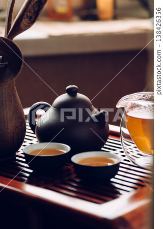 Teapot and cups with Chinese tea on the table Teapot and cups with Chinese tea on the table 138426356