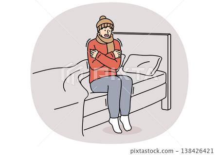 Freezing man is shaking sitting on bed and feeling chills and cold, dressed in hat and scarf Freezing man is shaking sitting on bed and feeling chills and cold, dressed in hat and scarf 138426421