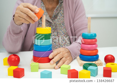 Asian elderly woman patient  learn practical motor game skills rehabilitation. 138426687