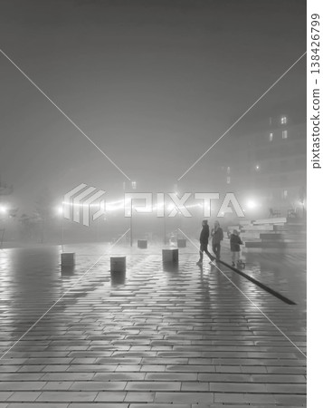 Foggy road in the city during evening or twilight with soft illuminated light. Moody urban landscape Foggy road in the city during evening or twilight with soft illuminated light. Moody urban landscape 138426799