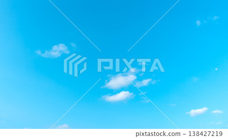 Vibrant blue sky with soft, scattered white clouds 138427219