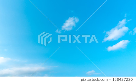 Clear blue sky with soft white clouds drifting gently Clear blue sky with soft white clouds drifting gently 138427220