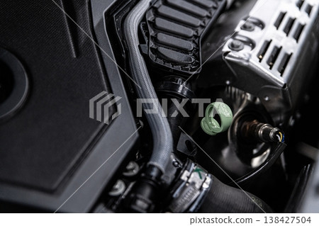 Engine oil dipstick check in car engine bay measuring oil level in modern vehicle close-up Engine oil dipstick check in car engine bay measuring oil level in modern vehicle close-up 138427504