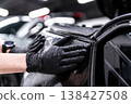 Applying PPF film on car headlights in professional detailing studio 138427508