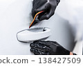 Applying PPF film on car door handle area protection against scratches in detailing studio close-up 138427509