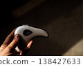 Hand holding modern microcurrent facial massager in warm sunlight with deep shadows, aesthetic beauty tech, minimalist skin care routine at home, sculptural guasha device, moody wellness concept. 138427633