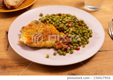 Appetizing crispy chicken with peas as side dish on plate Appetizing crispy chicken with peas as side dish on plate 138427958