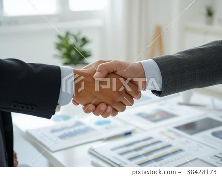 合約簽訂與合作的畫面：兩名身著西裝的商人握手。 138428173