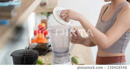 Woman preparing a smoothie in a modern kitchen 138428548