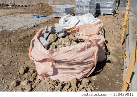Flexible container bags containing chunks of stone and concrete blocks placed on a vacant lot after the demolition of a house. Flexible container bags containing chunks of stone and concrete blocks placed on a vacant lot after the demolition of a house. 138429011