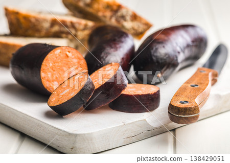 Smoked Blood Sausage Slices on White Cutting Board with Knife and Rustic Bread 138429051